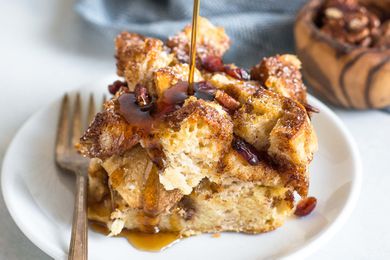 Syrup drizzling onto a French Toast Casserole on white plate with fork