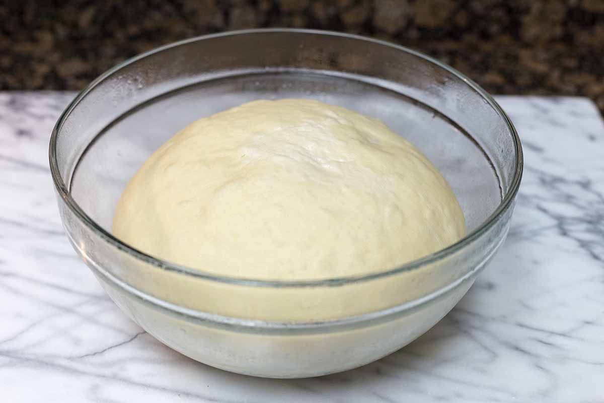 Dough for homemade cinnamon rolls in a glass bowl to show how to make cinnamon rolls.