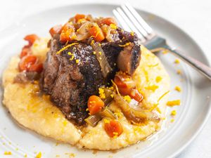 Beef Short ribs braised in the slow cooker and served with polenta on a round plate