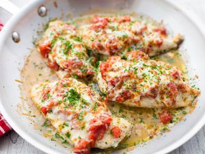 Cheesy Bruschetta Chicken Cutlets in a stainless steel skillet