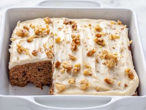 Applesauce cake, frosted and with a piece removed.