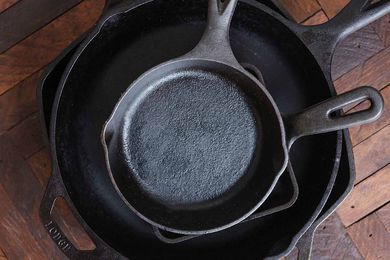 A stack of different sized cast iron skillets