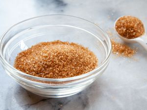 Sugar in the raw in a prep bowl with a teaspoon behind it.