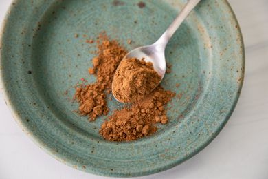 Chinese Five Spice on a Spoon with Some Overflowing onto a Plate