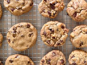 Twelve Neiman Marcus chocolate chip cookies sitting on a wire rack. 