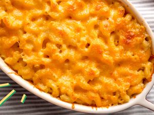 Photo of baked macaroni and cheese with some yellow and blue illustration on the corner of the picture