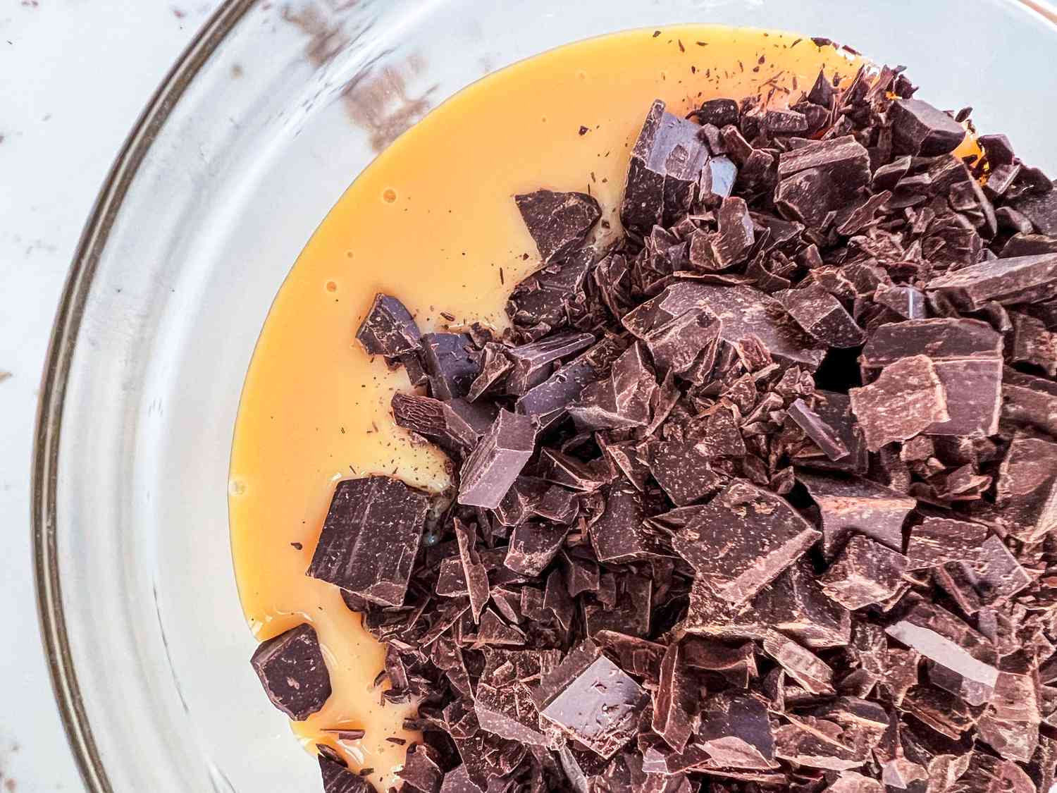 Chopped chocolate and sweetened condensed milk in a bowl.