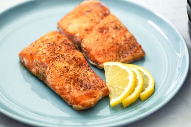 Air Fryer Salmon on a Plate with Lemon Wedges