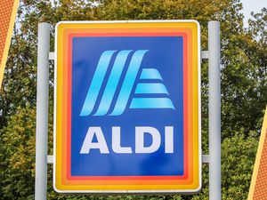 Photo of an Aldi store sign with orange and yellow lined and dotted illustrations on the corners of the photos