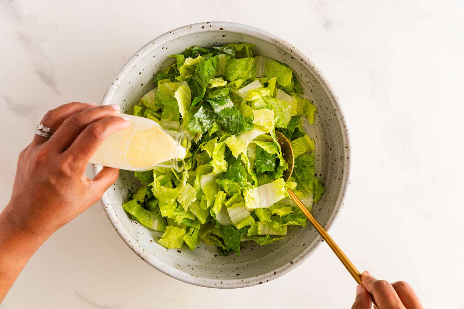 Jalapeno-lime dressing added to bowl of chopped romaine lettuce for banh mi salad recipe 