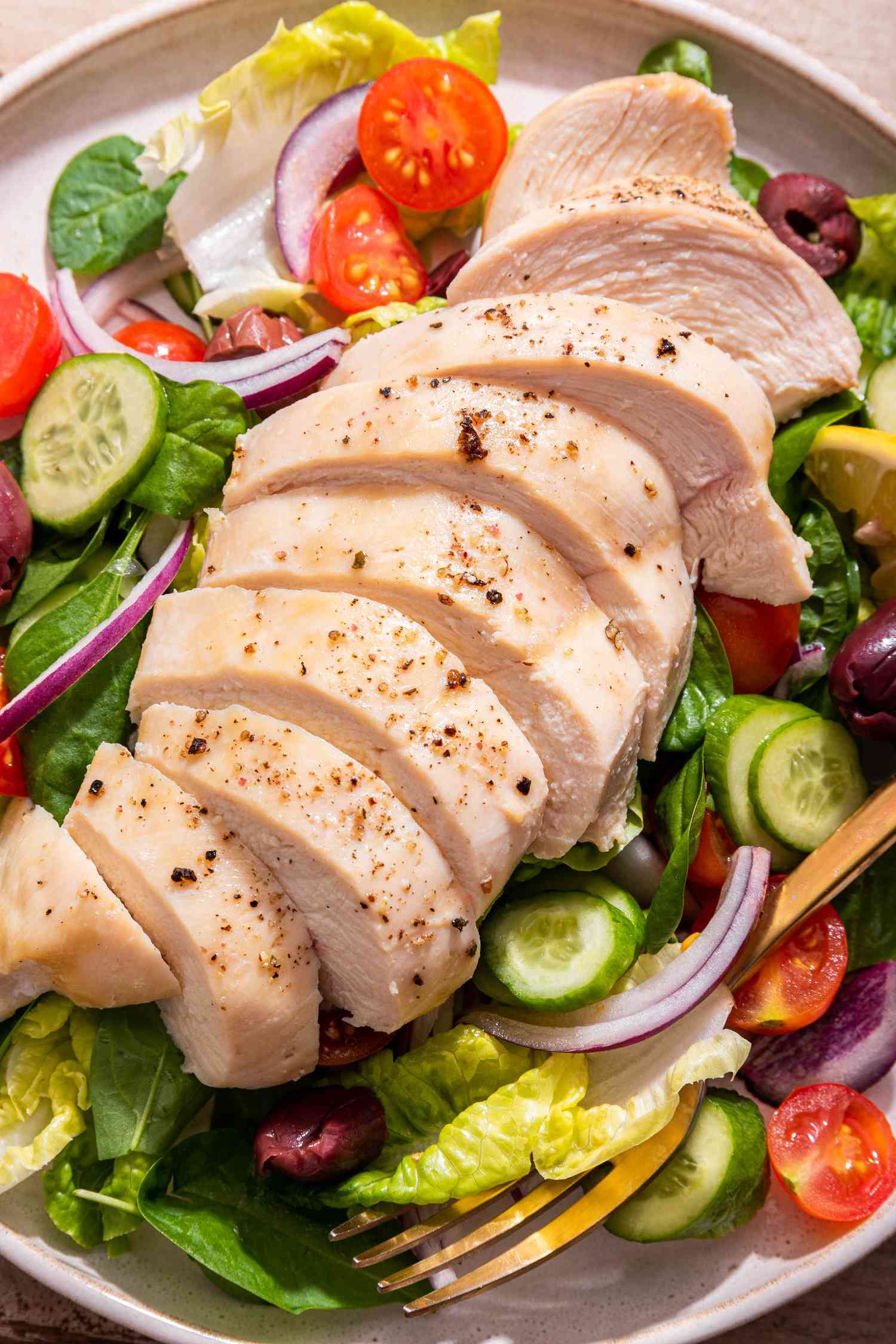 Close-up: sliced baked chicken breast with a salad on a plate 