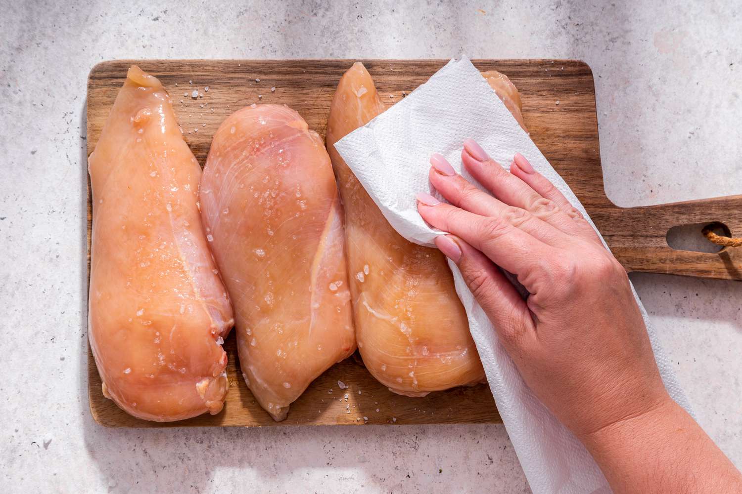 Paper towel used to pat the salted chicken breasts dry (still on the cutting board) for easy baked chicken breast recipe