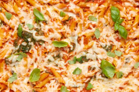 Close-up: one pan baked penne alla vodka topped with pieces of basil