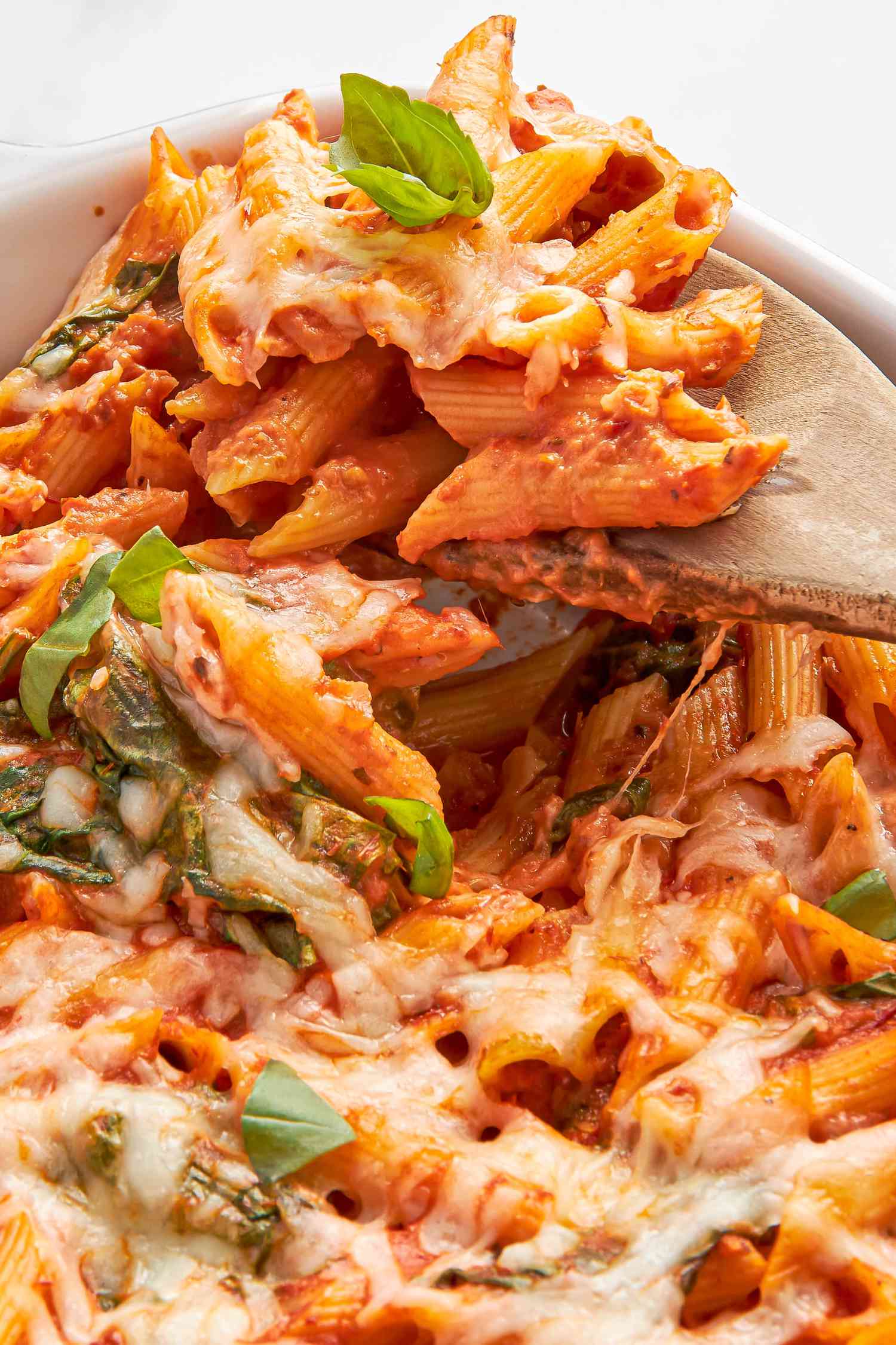 One pan baked penne alla vodka lifted from casserole dish using a wooden spoon