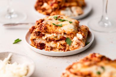 Side view of a piece of lasagna on a plate.