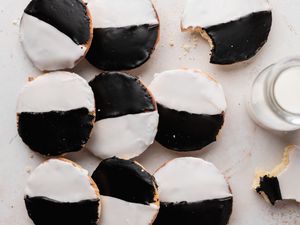 Overhead view of black and white cookies on a piece of parchment.