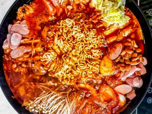 Budae Jjigae (Army Base Stew) in a large pot boiling on a portable induction stove
