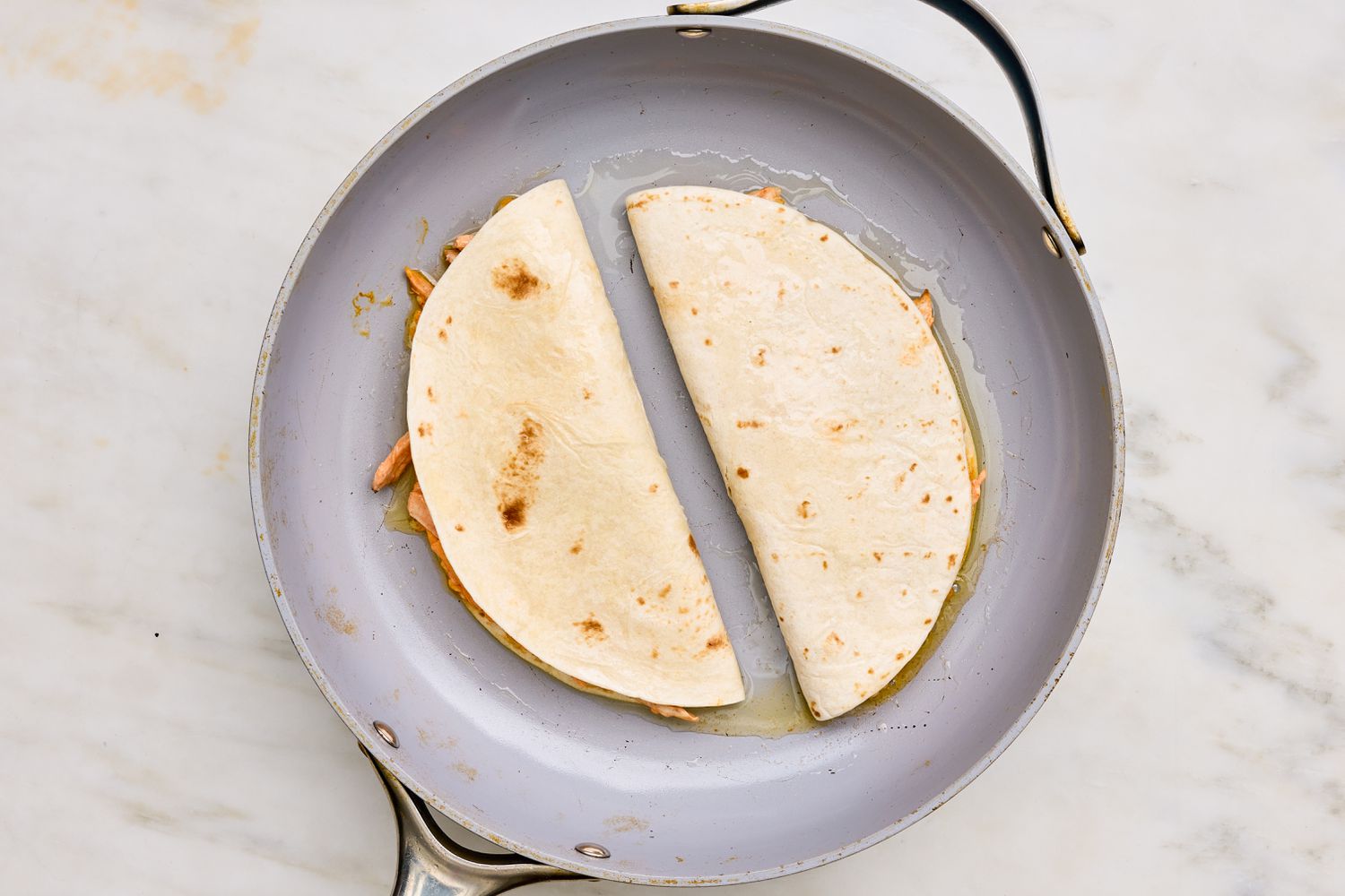 Oil added to the pan with buffalo chicken quesadillas 