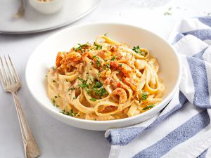 Cajun shrimp alfredo in a white bowl with a fork on the side