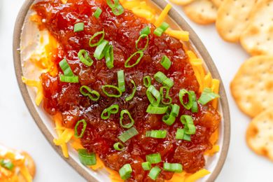 Platter of cheese chutney appetizer with crackers on the counter next to it