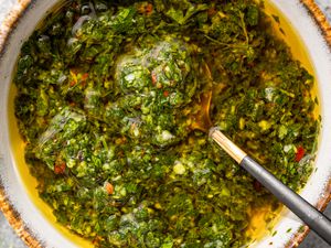 A bowl of chimichurri with a spoon in it