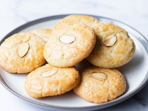 Almond cookies scattered on a rimmed plate.