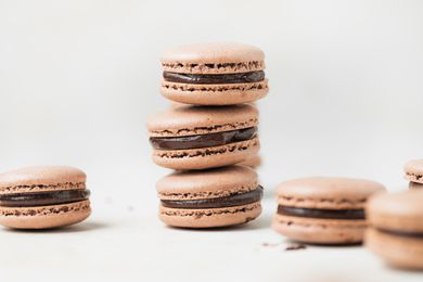 Double chocolate macarons stacked on a white background.
