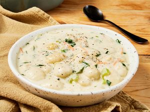 Bowl of copycat Olive Garden chicken and gnocchi soup on a beige table napkin 