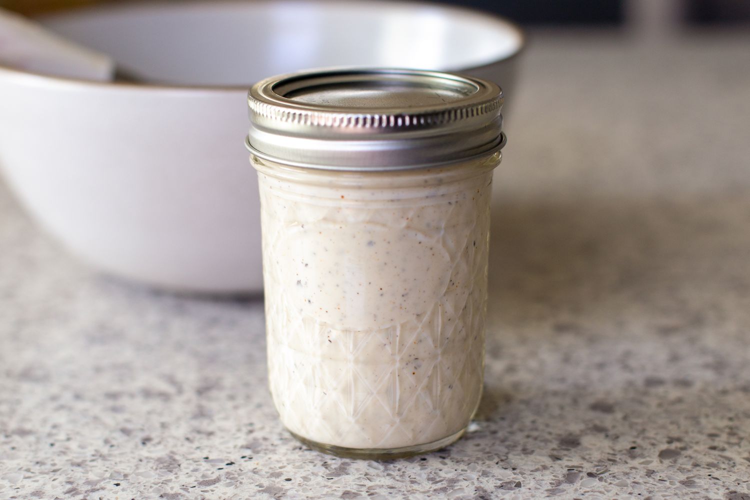 Peppercorn Sauce in a Mason Jar, and in the Background, a Bowl and a Whisk