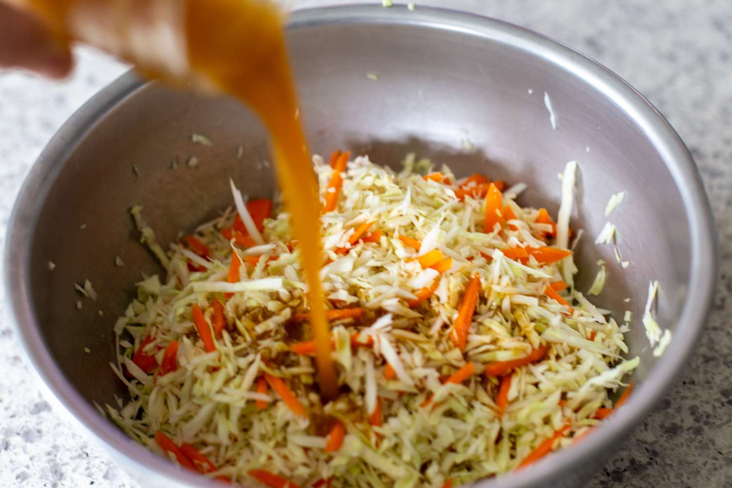 Slaw Dressing Added to Bowl of Shredded Vegetables