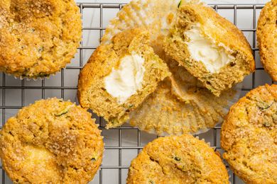 Cream Cheese Zucchini Muffins With One Cut in Half, All on a Cooling Rack