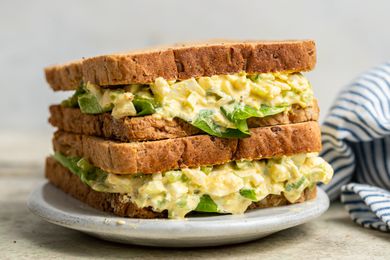 Homemade egg salad sandwich on a plate with a leaf of lettuce