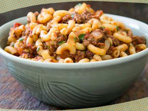 Photo of Elise's hamburger helper in a bowl surrounded by dark yellow and blue illustrations 