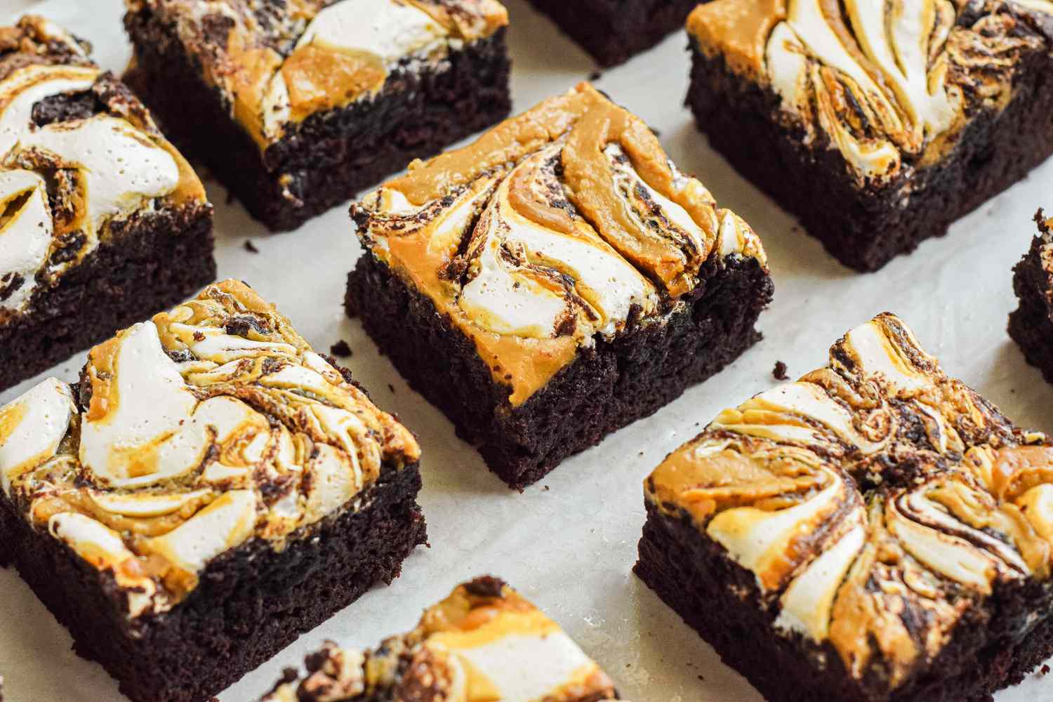 Fluffernutter brownie cut into squares on a piece of parchment paper