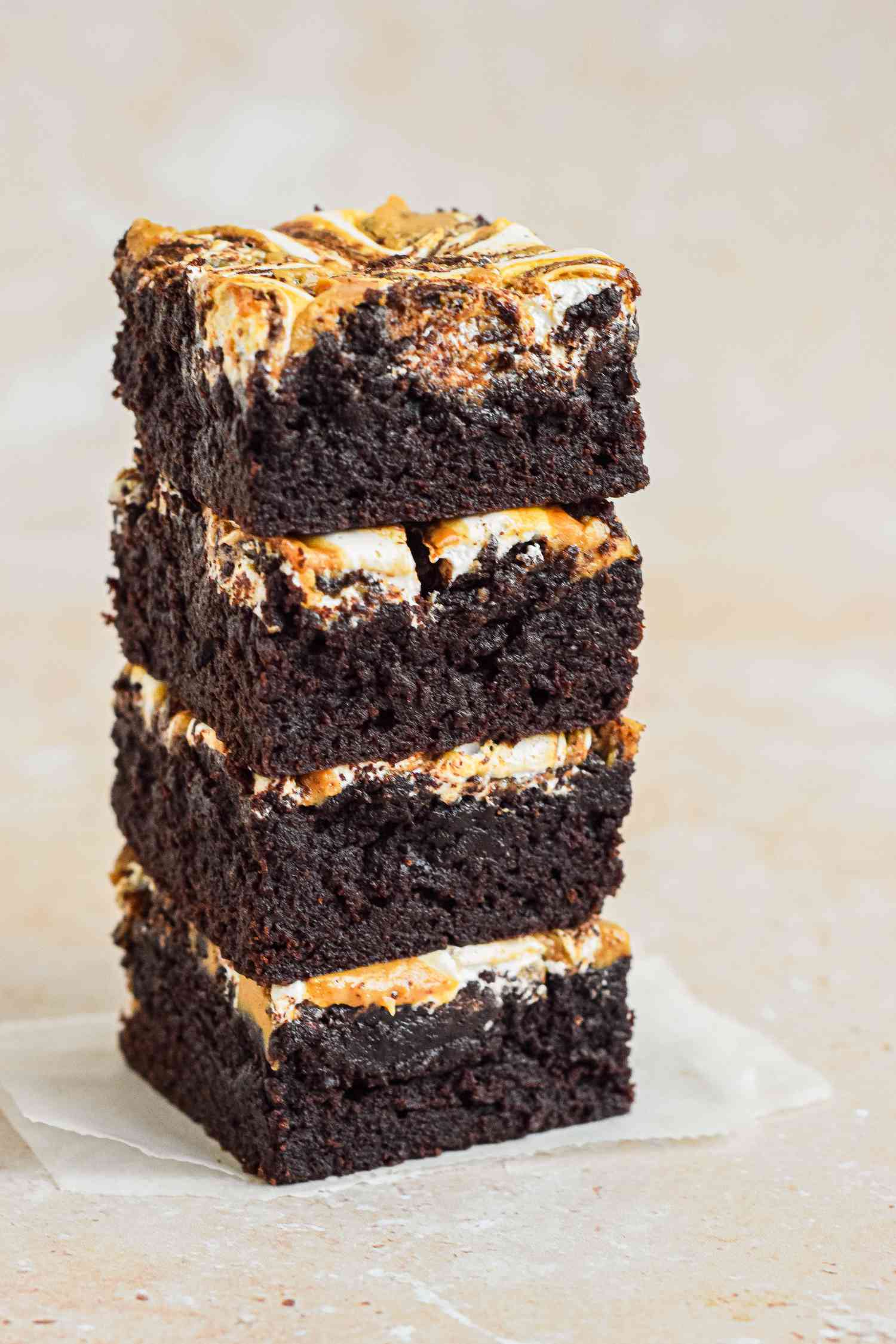 Stack of fluffernutter brownies on a small piece of parchment paper