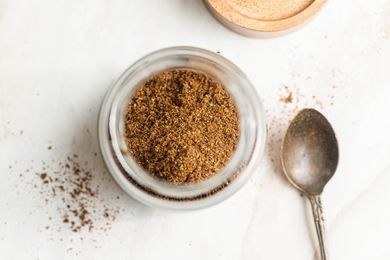 Jar of Garam Masala Next to a Spoon and Jar Lid