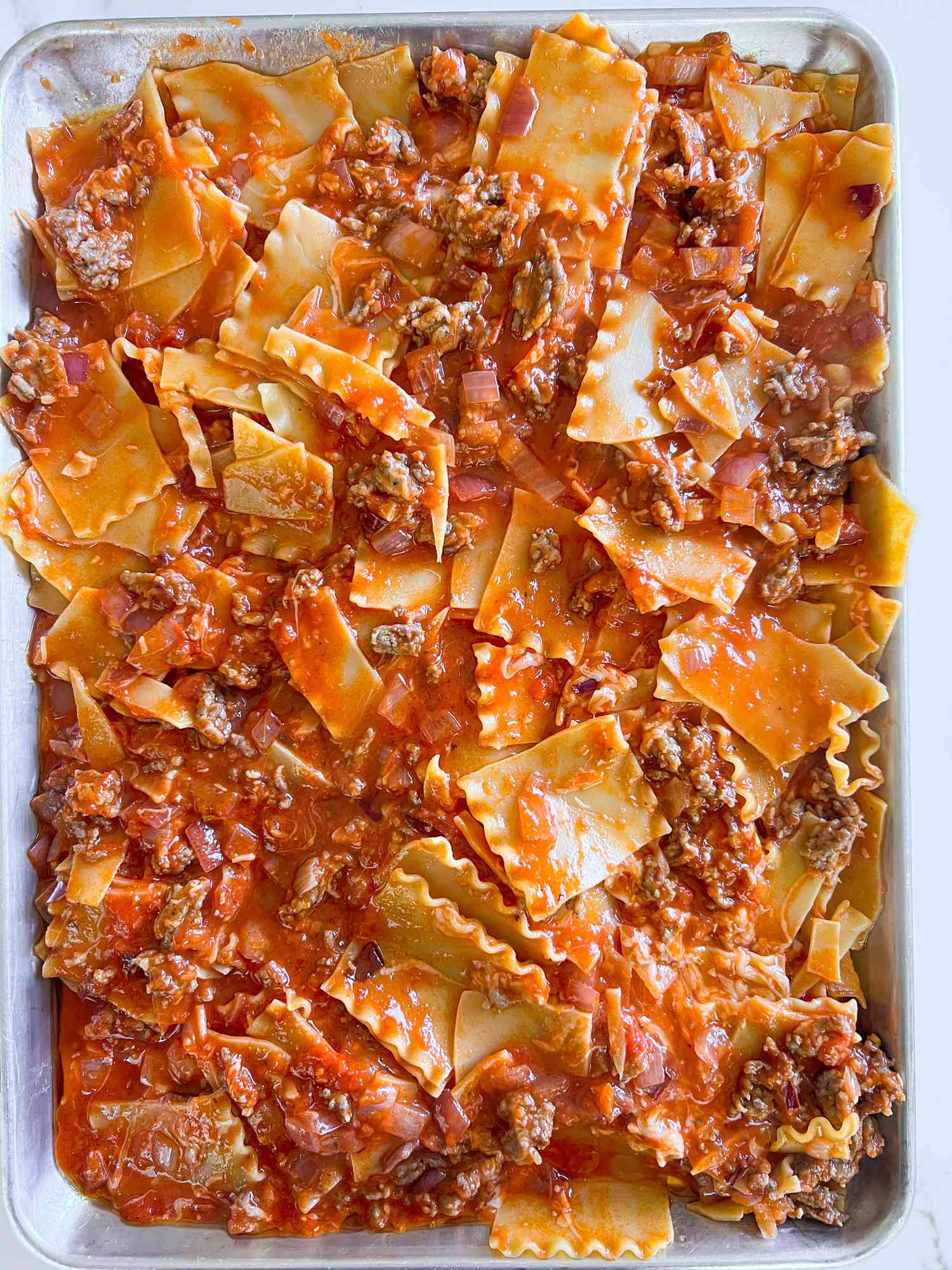 Lasagna and sauce in a sheet pan