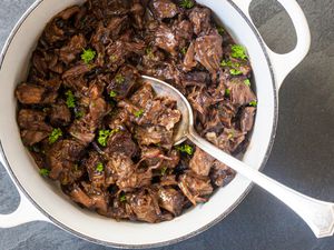 Overhead view of a dutch oven with braised oxtails inside for an oxtail recipe.