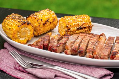 Grilled steak and corn on a platter