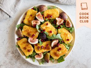 Overhead view of a bowl of Halloumi saganaki: pan-seared Greek cheese with pomegranates and figs.