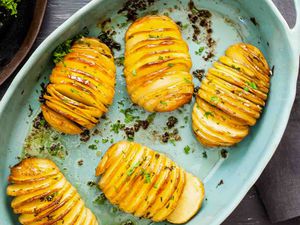 Five hasselback potatoes in a roasting dish