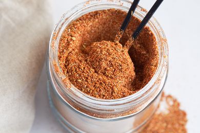 A jar of Cajun seasoning with a spoon in it