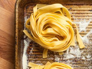 Unrolled Tagliatelle Bundles on a Semolina Dusted Baking Sheet