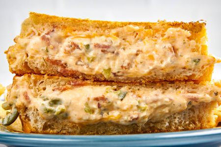 Cross-section of jalapeÃ±o popper grilled cheese (two sandwich halves) stacked on a plate