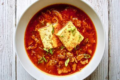 Overhead view of a bowl of spicy kimchi and pork belly stew.