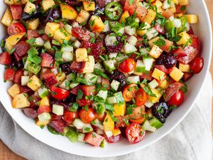 Bowl filled with stone fruit, tomato, and cucumber salad