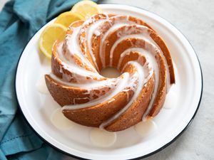 The BEST Lemon Yogurt Cake on a platter along with lemon slices.