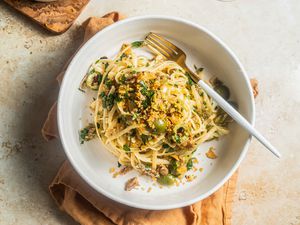 Lemony Sardine Pasta Topped With Toasted Breadcrumbs in a Bowl Sitting on a Mustard Colored Table Linen