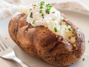 Baked potato topped with sour cream, pepper, and chives