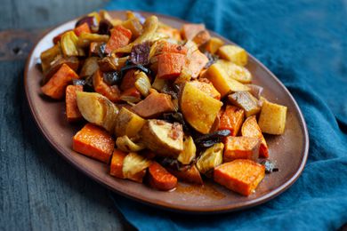 Quick and easy roasted vegetables on a platter with a teal linen underneath.